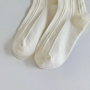Gros plan de chaussettes blanches en maille ajourée avec texture délicate et tissu en coton
