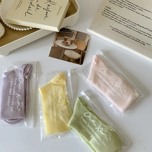 Détail de chaussettes en coton côtelé coloré dans un emballage zippé de marque