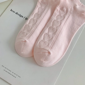 Detailed close-up of pink lace cotton socks with heart jacquard pattern and ribbed cuffs