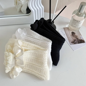 Détails des volants en dentelle et des nœuds en satin sur des chaussettes en maille
