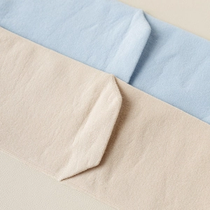 Detailed close-up showing light blue and apricot fine ribbed knit cotton blend fabric texture