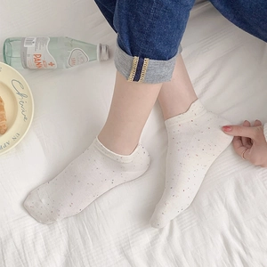 Detail of white cotton low-cut socks with colorful dots and elastic ribbed cuffs