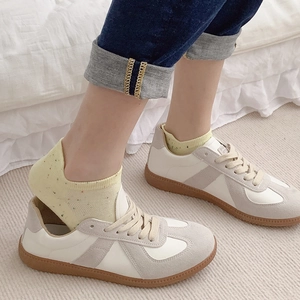 Classic leather trainers with gray suede overlays and yellow polka dot boat socks for women