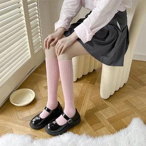 Calze rosa al polpaccio in maglia a righe abbinate a scarpe Mary Jane con plateau nero