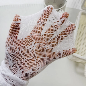 Detailed macro shot of white lace floral mesh gloves with high elasticity and sheer texture
