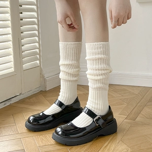 Calze al polpaccio in maglia bianco panna con scarpe Mary Jane in vernice nera lucida