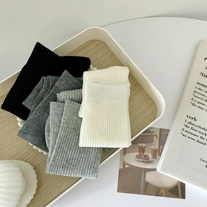 Détail de la texture côtelée en maille des chaussettes d'été en noir, gris et blanc cassé