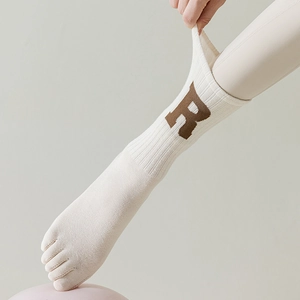 Detail von Yoga-Zehensocken mit gestricktem R-Buchstaben-Design und gerippten Bündchen