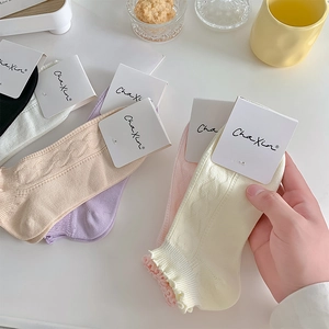 Close-up of pastel cotton socks with wavy ruffle edges in macaron colors and gift card