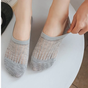 Close-up of thin grey no-show socks with vertical stripes and high elastic heel