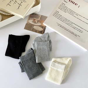 Détail de quatre paires de chaussettes en maille côtelée en noir, gris et crème