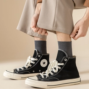 Men's dark grey ribbed crew socks paired with classic black high-top canvas sneakers