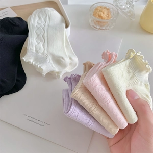 Detail of ruffled cuffs on cotton socks featuring heart patterns in various pastel colors