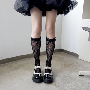 Japanese Lolita style knee high fishnet socks with lace trim and black bow accents