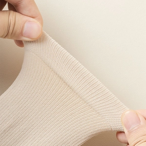 Close-up showing the high elasticity and fine knit texture of these beige tabi socks