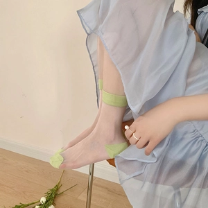 Detail view of light green ultra-thin transparent crystal socks with solid color heels