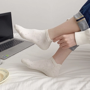Close-up of white cotton blend boat socks with colorful speckles and ribbed cuffs for women