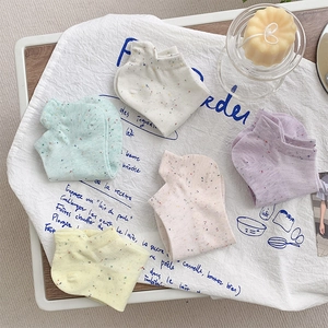 Five pairs of speckled cotton boat socks in pastel colors displayed on a rustic fabric