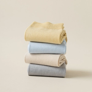 Detail of four-color ribbed cotton split toe socks in mustard, blue, beige, and gray