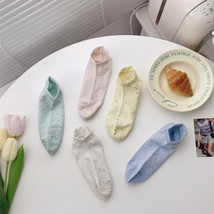 Detailed view of colorful pastel low cut cotton socks with speckled knit on a table