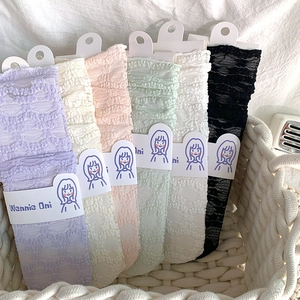 Detailed view of lace bubble socks in various pastel colors inside a woven basket
