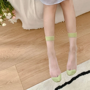 Detail of sheer glass socks with light green toe and cuff color block design
