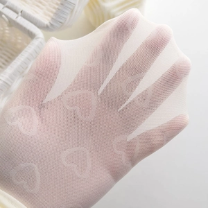 Gros plan sur les chaussettes blanches à motifs de cœurs montrant l'élasticité et la texture