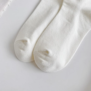 Gros plan de chaussettes de ballet blanches en tricot côtelé montrant la texture douce