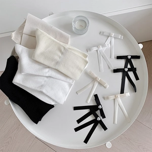 Détail de chaussettes en tricot style Lolita et pinces à nœud avec perles de cœur