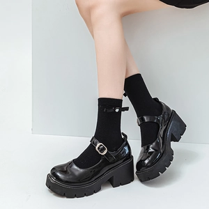 Side view of black patent leather Mary Jane shoes with thick soles and metal buckles