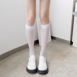 Détail de chaussettes blanches transparentes à motif cœurs et mocassins à plateforme