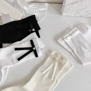 Détail de chaussettes avec nœuds en soie et perles en forme de cœur style ballet