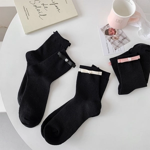Close-up of ballet style bow socks with pearl heart buttons and knit texture detail
