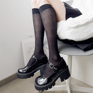 Détail de chaussettes mi-bas noires transparentes à motifs cœurs et chaussures Mary Jane