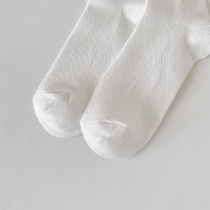 Macro detail of breathable mesh knit texture and fine stitching on white socks