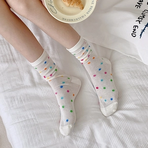 Close-up of white breathable mesh mid-calf socks with colorful polka dots and heart patterns