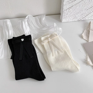 Détail de chaussettes style ballerine avec nœuds en soie et perles en cœur