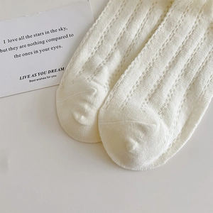 Close-up of white breathable mesh pattern and knit texture on summer cotton socks
