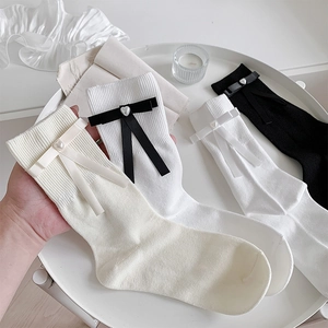 Détail de chaussettes style ballet avec nœuds, perles en cœur et maille côtelée