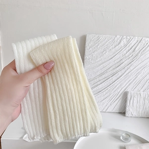 Close-up of white ribbed knit Lolita leg warmers with soft textured fabric detail