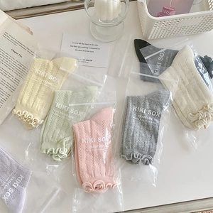 Flat lay of colorful mesh ruffle socks in pastel tones with elegant gift packaging