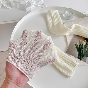 Detail of cream white knit leg warmer with vertical stripes and hollow mesh texture