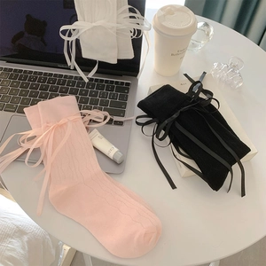 Detail of balletcore mesh socks featuring silk satin bow ties and vertical ribbed texture