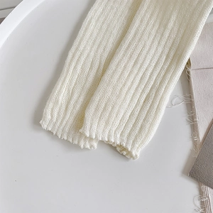Close-up detail of white knitted Lolita leg warmers showing elastic vertical rib textures