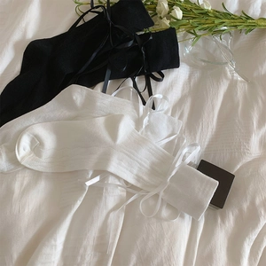 Detail of breathable white mesh socks with ribbon bows in ballet style aesthetic