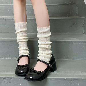 Lolita style white knitted leg warmers paired with black patent leather Mary Jane shoes