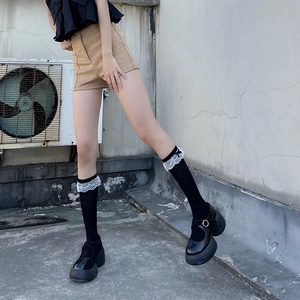 Détail de chaussettes Lolita avec dentelle blanche et nœud noir sur chaussures Mary Jane