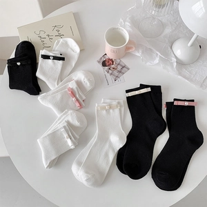Detail of sweet bow and pearl accents on white and black JK style crew socks
