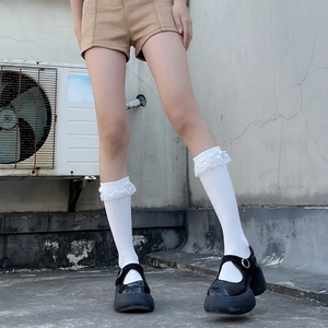 Détail de chaussettes Lolita blanches avec bordure en dentelle et petit nœud ruban