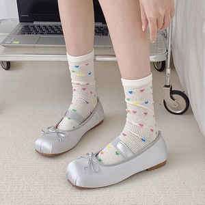 Detail of silver satin Mary Jane ballet flats with bow and heart pattern mesh socks